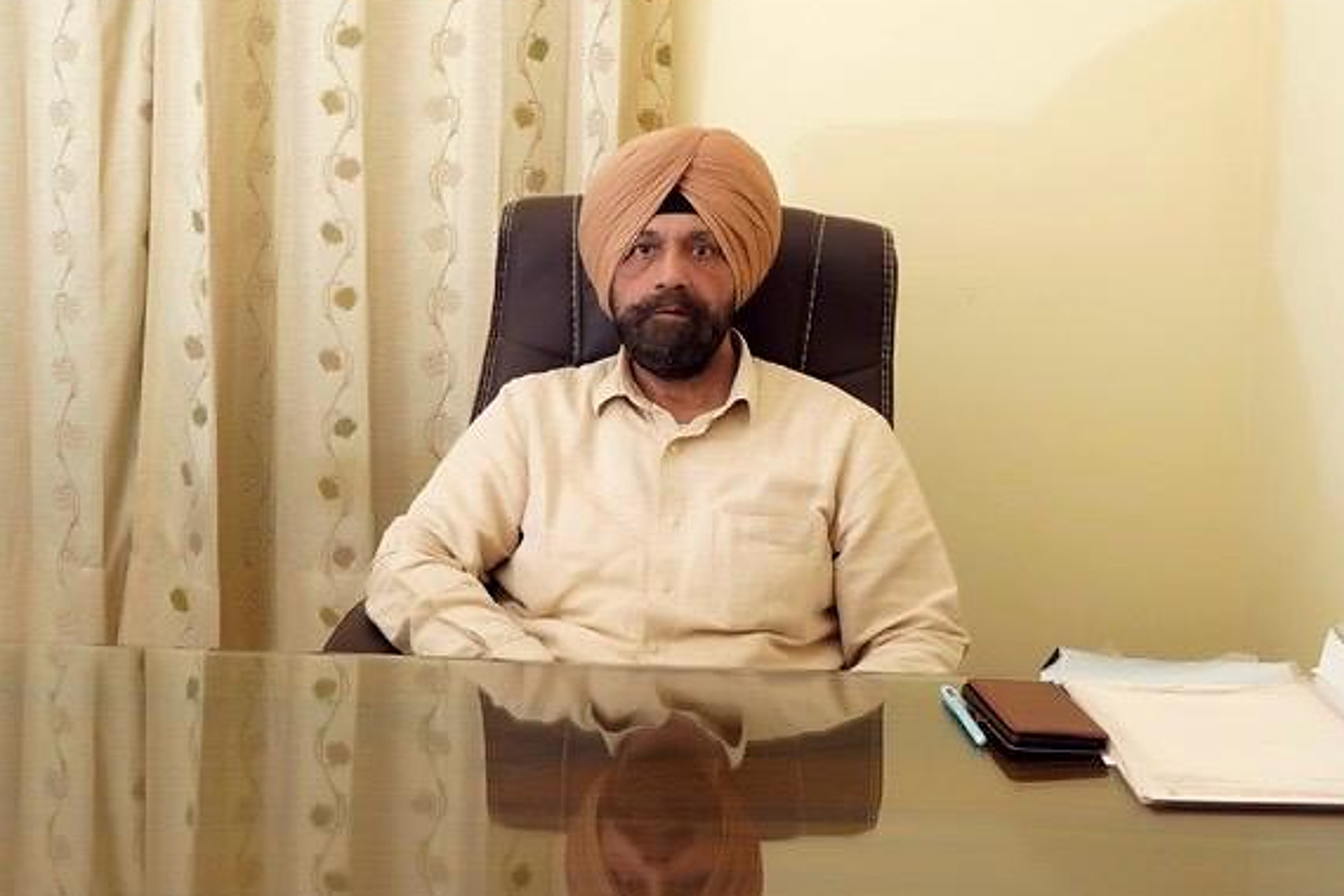 Dr. Tejinder Sidhu at his desk in the clinic